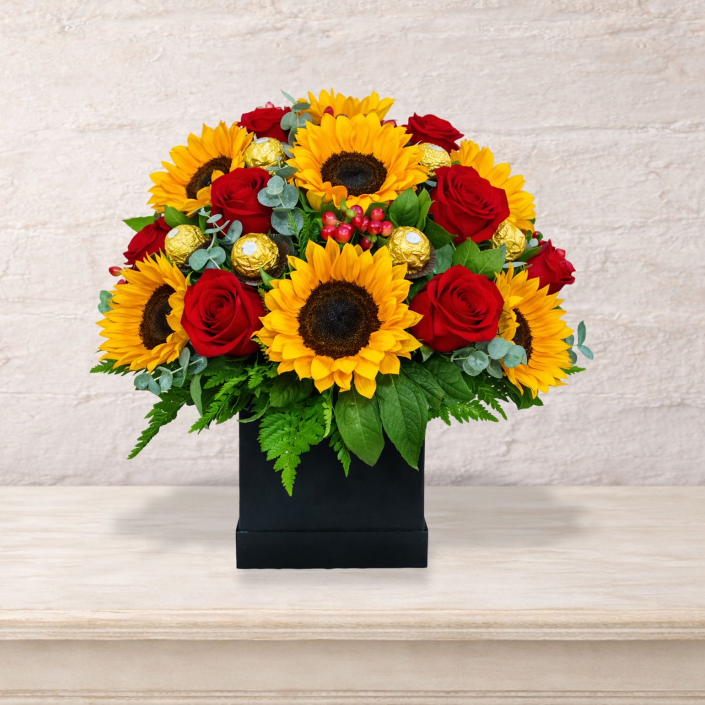 Arreglo floral premium con girasoles, rosas rojas y chocolates Ferrero Rocher en base negra elegante, envío local en Monterrey