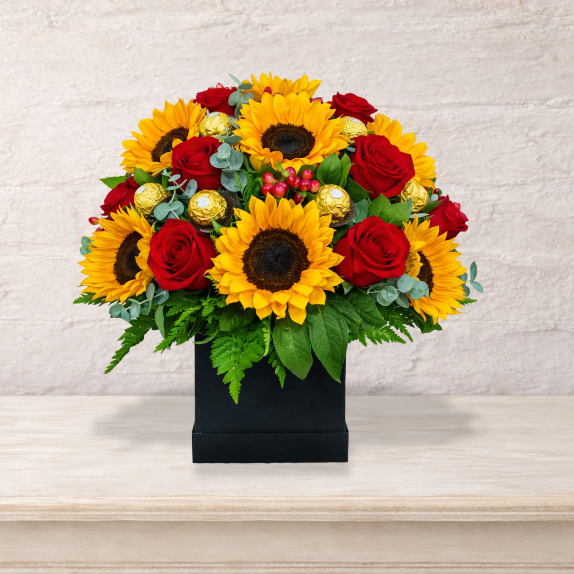 Arreglo floral premium con girasoles, rosas rojas y chocolates Ferrero Rocher en base negra elegante, envío local en Monterrey
