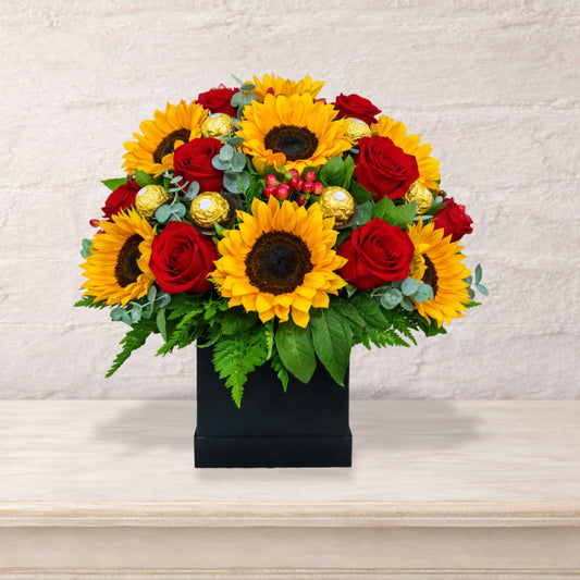 Arreglo floral premium con girasoles, rosas rojas y chocolates Ferrero Rocher en base negra elegante, envío local en Monterrey