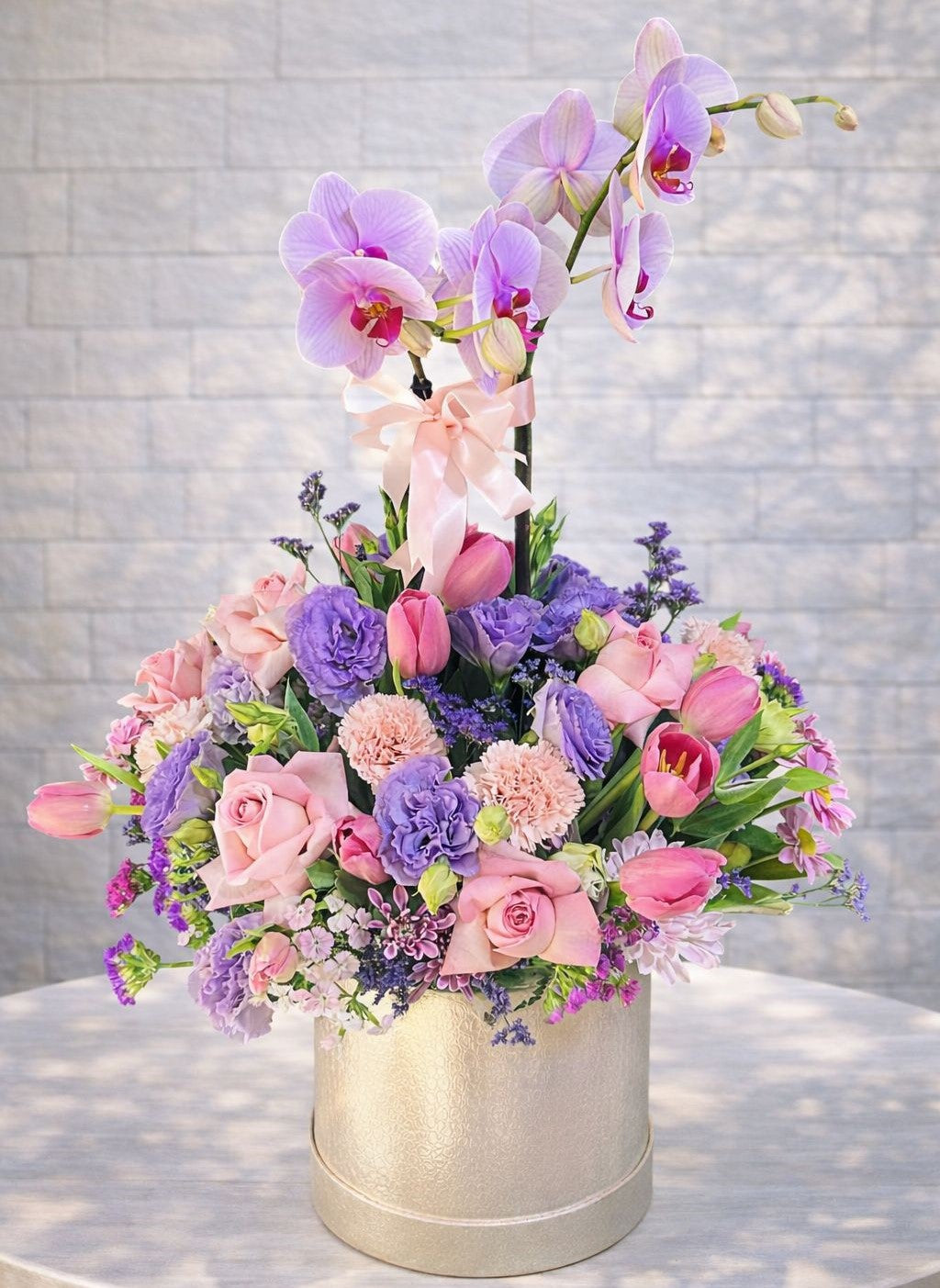 Arreglo premium on orquídea lila, rosas rosas y tulipanes en caja elegante para flores a domicilio en Monterrey.