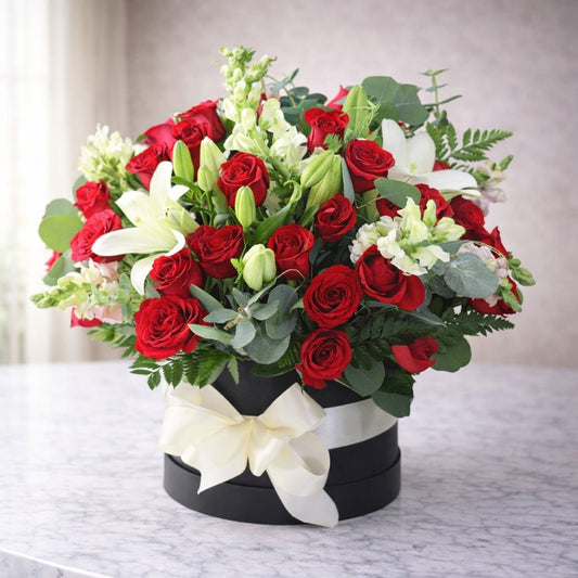 Arreglo floral premium con rosas rojas y lirios blancos en caja negra elegante con moño, ideal para regalar en Monterrey y área metropolitana