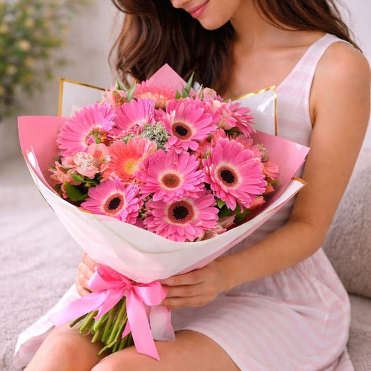Ramo de gerberas rosas envuelto en papel elegante con lazo rosa, ideal para regalo romántico y disponible con flores a domicilio en Monterrey.