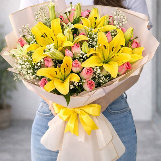 Ramo de lirios amarillos y rosas rosadas con envoltura elegante y lazo amarillo, arreglo floral premium disponible con envío  a domicilio en Monterrey por Pink Rose Floreria