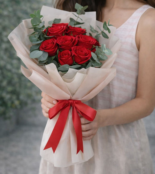 Ramo elegante de rosas rojas con envoltura beige y lazo rojo, disponible con flores a domicilio en Monterrey con entrega el mismo día para ocasiones románticas.