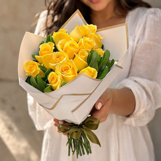 Ramo de rosas amarillas con follaje verde y envoltura premium disponible con entrega de flores a domicilio en Monterrey.