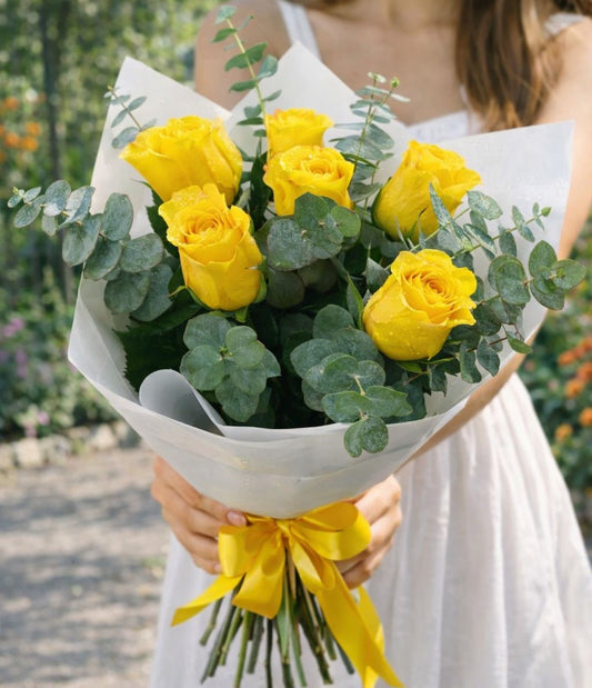 Ramo de rosas amarillas frescas con follaje de eucalipto y envoltura elegante disponible con entrega de flores a domicilio en Monterrey.