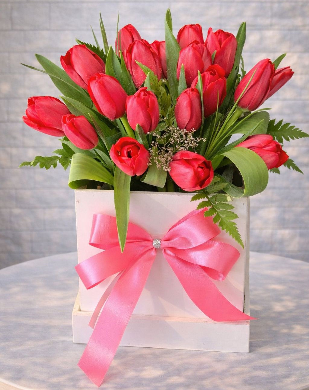 Arreglo de tulipanes rojos en caja blanca con lazo rosa, ideal para regalo romántico, aniversario y flores a domicilio en Monterrey | Pink Rose 